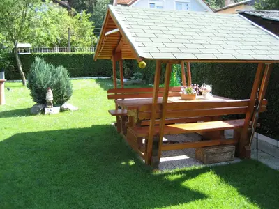 a wooden gazebo with a roof on the grass at Mekina Guesthouse in Maribor