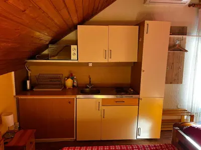 a small kitchen with white cabinets in a room at Mekina Guesthouse in Maribor