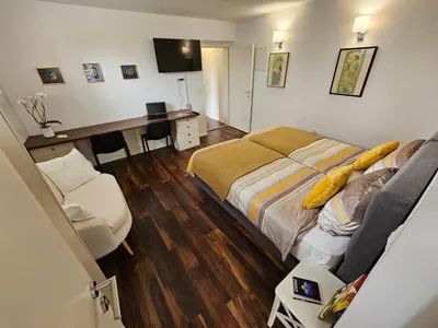 a bedroom with a bed and a desk with a computer at APARTMA FIREFLY1 in Ljubljana