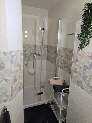 a bathroom with a shower with a chair and a stool at APARTMA FIREFLY1 in Ljubljana