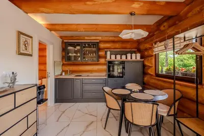 a kitchen with wooden walls and a table and chairs at Chalet -VV in Podčetrtek