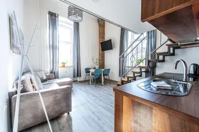a living room with a couch and a sink in a room at The Wonderful Loft in Ljubljana