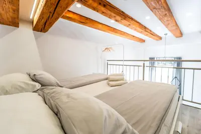 a bedroom with white walls and wooden beams at The Wonderful Loft in Ljubljana