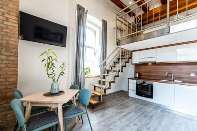 a kitchen and dining room with a table and chairs at The Wonderful Loft in Ljubljana