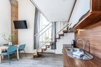 a kitchen with a sink and a staircase at The Wonderful Loft in Ljubljana