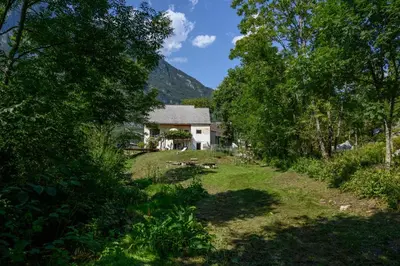 a house in the middle of a field with trees at Stara Hiša in Log Čezsoški