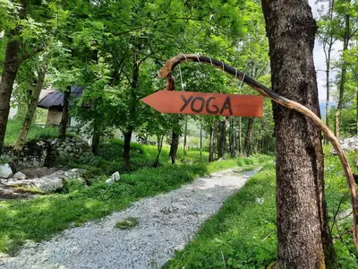 a sign that says yoga hanging on a tree at Stara Hiša in Log Čezsoški