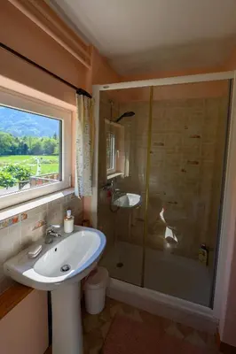 a bathroom with a sink and a shower with a window at Stara Hiša in Log Čezsoški