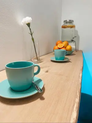 a wooden table with a cup and a bowl of oranges at Lavitas SPA in Moravče