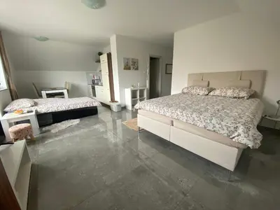 a bedroom with two beds and a tile floor at Apartma Azurre in Postojna