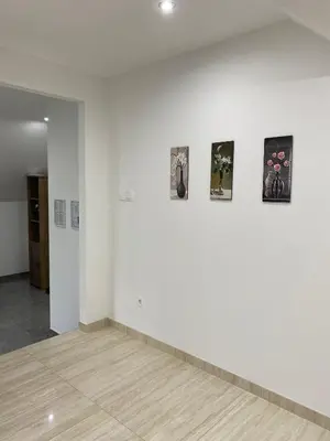 a room with white walls and pictures on a wall at Apartma Azurre in Postojna