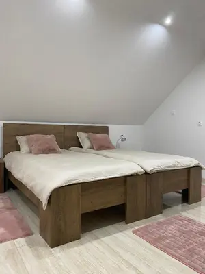 a large wooden bed in a white room with at Apartma Azurre in Postojna
