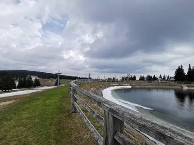 a wooden fence next to a body of water at Pocket apartment Rogla - Gaber 121 in Zreče
