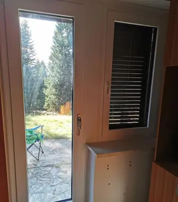 a door with a window with a view of a yard at Pocket apartment Rogla - Gaber 121 in Zreče