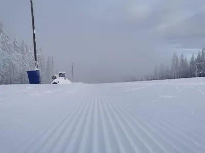 a snow covered road with a pole in the snow at Pocket apartment Rogla - Gaber 121 in Zreče