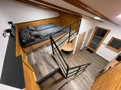 a loft bedroom with a bed and a staircase at Apartma Mia in Črni Kal