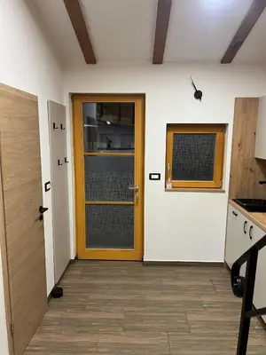 a hallway with a yellow door and a kitchen at Apartma Mia in Črni Kal