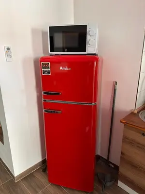 a red refrigerator with a microwave on top of it at Apartma Mia in Črni Kal