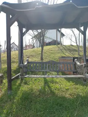 a park bench under a gazebo in the grass at Bellevue mini House in Žetale