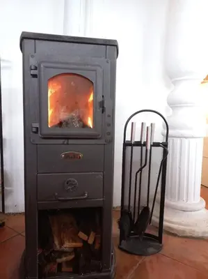 a wood stove with a fire in a room at Bellevue mini House in Žetale
