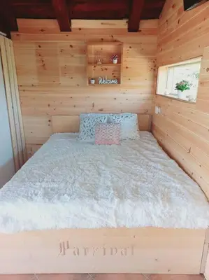 a bedroom with a bed in a wooden cabin at Bellevue mini House in Žetale