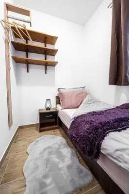 a bedroom with two beds and a wooden floor at Apartmaji Koza in Zgornje Gorje
