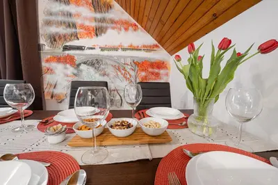 a table with wine glasses and bowls of food at Apartmaji Koza in Zgornje Gorje