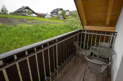 a patio with a table and chairs on a porch at Apartmaji Koza in Zgornje Gorje