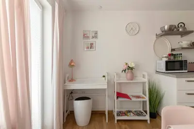 a white kitchen with a desk and a microwave at Ljubljana studio with FREE parking, Washer & Dryer in Ljubljana
