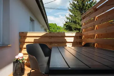 a wooden table and chairs on a patio at Ljubljana studio with FREE parking, Washer & Dryer in Ljubljana