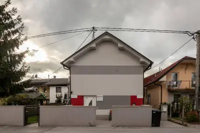 a white and red building in front of some houses at Ljubljana studio with FREE parking, Washer & Dryer in Ljubljana