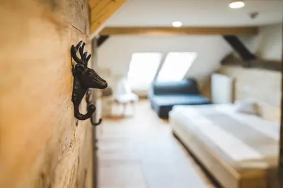 a room with a wall with a deer head on it at Tourist Farm Šenkova Domačija in Zgornje Jezersko