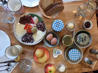 a wooden table topped with plates and bowls of food at Tourist Farm Šenkova Domačija in Zgornje Jezersko