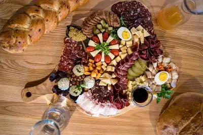a plate of food on a wooden table at Tourist Farm Šenkova Domačija in Zgornje Jezersko