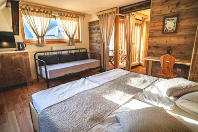 a bedroom with a bed and a couch in it at Tourist Farm Šenkova Domačija in Zgornje Jezersko