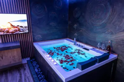 a bathroom with a large tub filled with water at Villa Sunset Pool & Spa apartments in Zgornje Škofije
