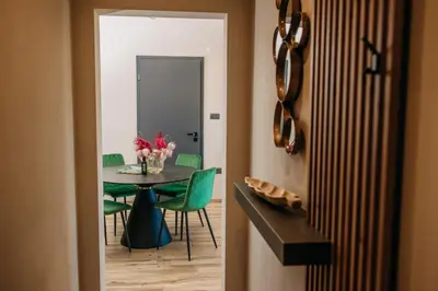 a dining room with a table and green chairs at Villa Sunset Pool & Spa apartments in Zgornje Škofije