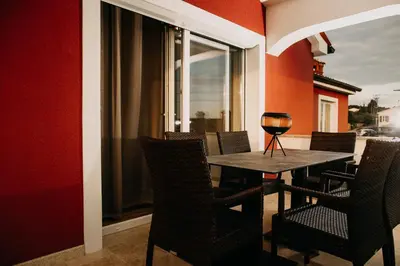 a table with chairs and a wine glass on it at Villa Sunset Pool & Spa apartments in Zgornje Škofije