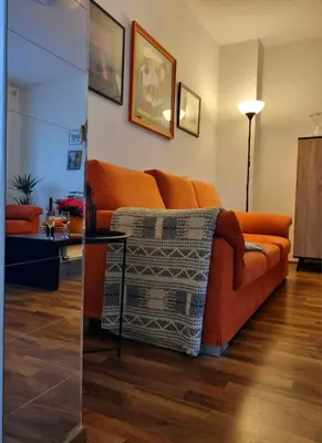 an orange couch sitting in a living room at Apartma Vista montana in Kobarid