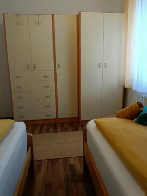 a bedroom with two beds and white cabinets at Apartma Vista montana in Kobarid