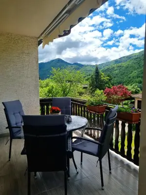 a balcony with a table and chairs and a view at Apartma Vista montana in Kobarid