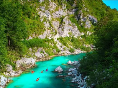 a group of people are rafting down a river at Apartma Vista montana in Kobarid