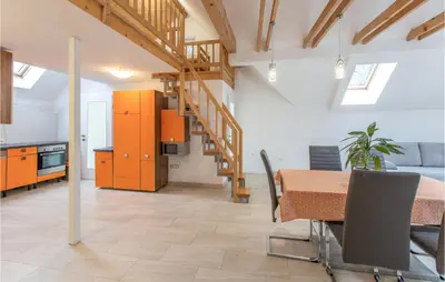a kitchen and dining room with a table and a staircase at 1 Bedroom Stunning Apartment In Col in Zoll