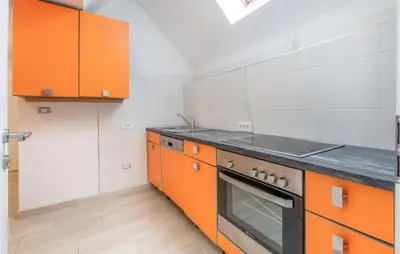 a kitchen with orange cabinets and a stove top oven at 1 Bedroom Stunning Apartment In Col in Zoll