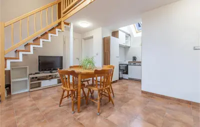 a dining room with a table and chairs and a staircase at 1 Bedroom Nice Apartment In Col in Zoll