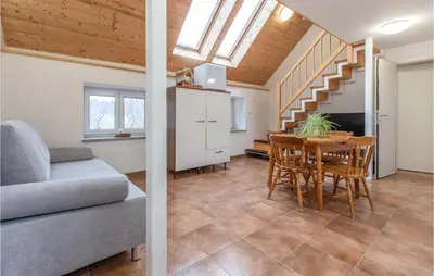 a living room with a dining room table and a staircase at 1 Bedroom Nice Apartment In Col in Zoll