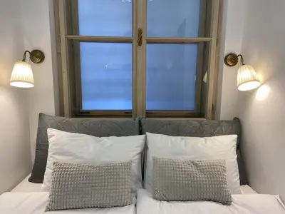 a bedroom with a bed with two pillows and a window at Apartment Breg - Old town river in Ljubljana