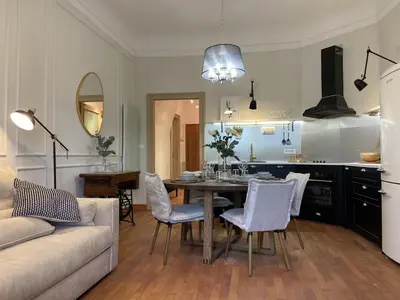a kitchen and living room with a table and chairs at Apartment Breg - Old town river in Ljubljana