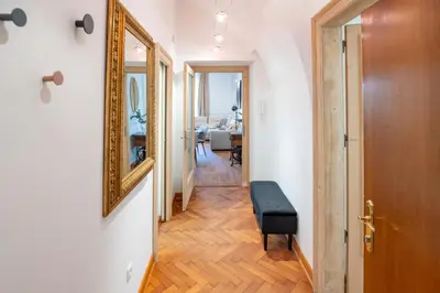 a hallway with a mirror and a chair in a room at Apartment Breg - Old town river in Ljubljana