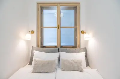 a bedroom with a window above a bed with pillows at Apartment Breg - Old town river in Ljubljana